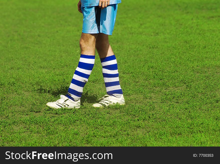 Soccer player's legs on green field