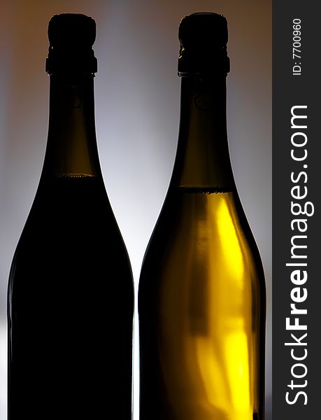 Champagne bottles against background with light spot on it. Champagne bottles against background with light spot on it.