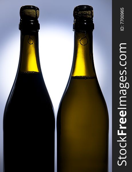 Champagne bottles against background with light spot on it. Champagne bottles against background with light spot on it.