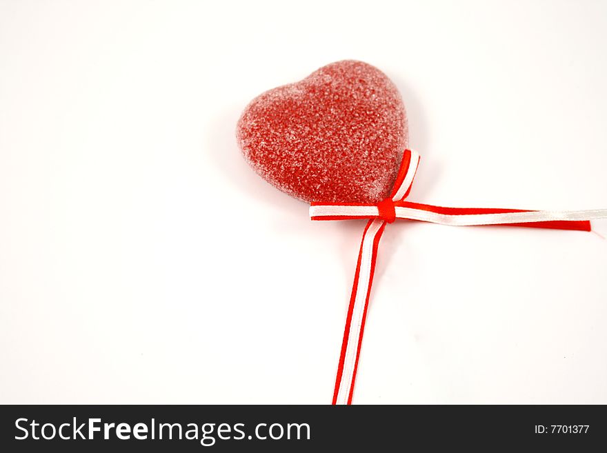 Candy heart with red bow on white background