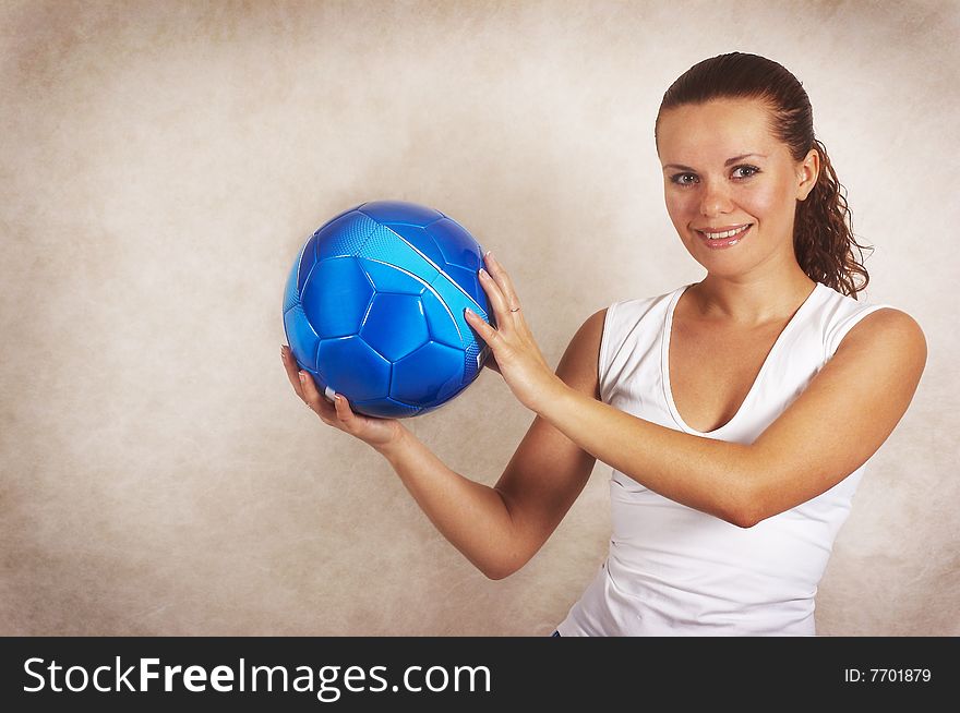 The girl holds in hands a light-blue football ball. The girl holds in hands a light-blue football ball