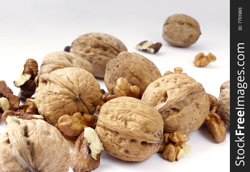 Whole and split walnuts on a white background