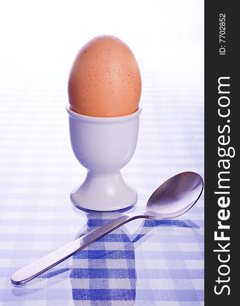 Soft boiled egg in egg cup with spoon. Soft boiled egg in egg cup with spoon