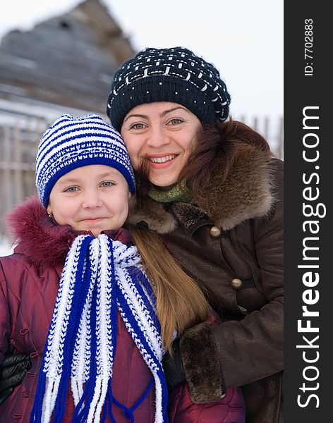 Woman with a young girl in a cap and scarf