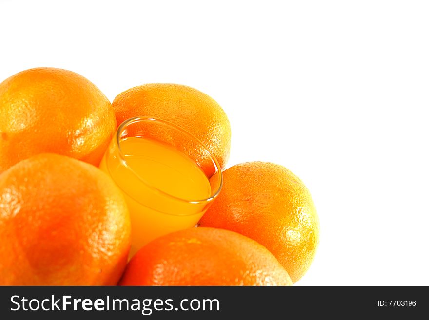 Orange juice in a glass and oranges on a white background