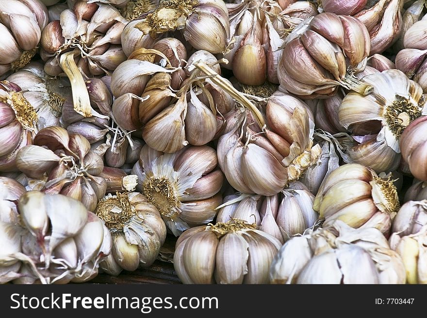 Many colourful garlic cloves in a basket in a market.