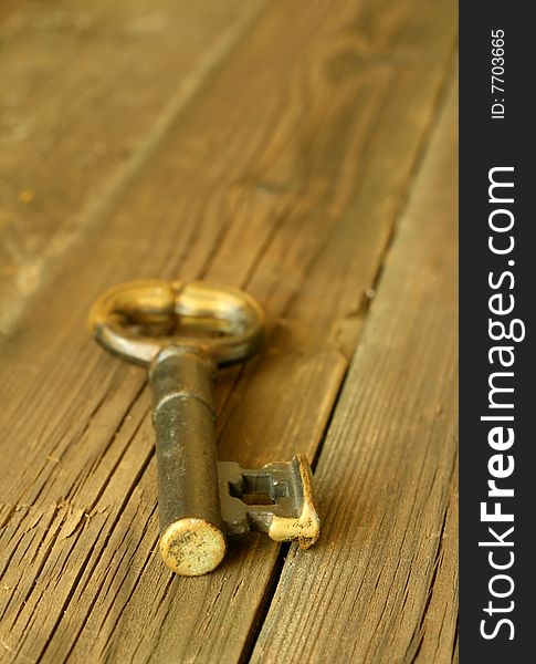 Old metal key on wooden, closeup