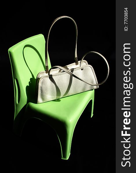 Women handbag on green chair