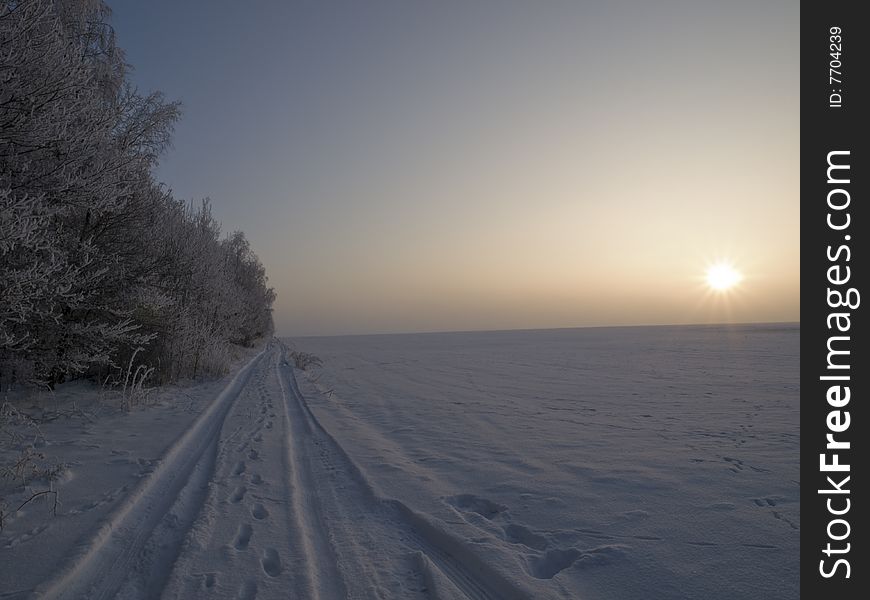 Image of the tracks in the snow takeÅ„ during winter sunset