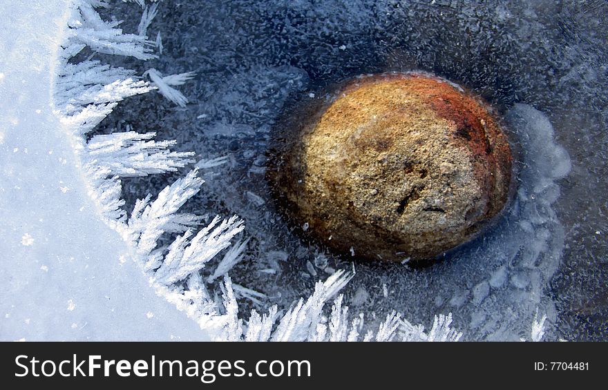 Red Pebble inside a frozen River. Red Pebble inside a frozen River