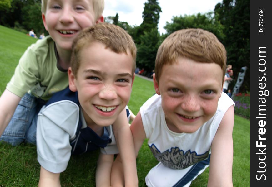 A photograph of three boys playing in summer