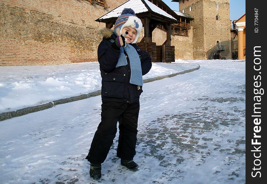 Portrait of child on a background an old castle in winter time