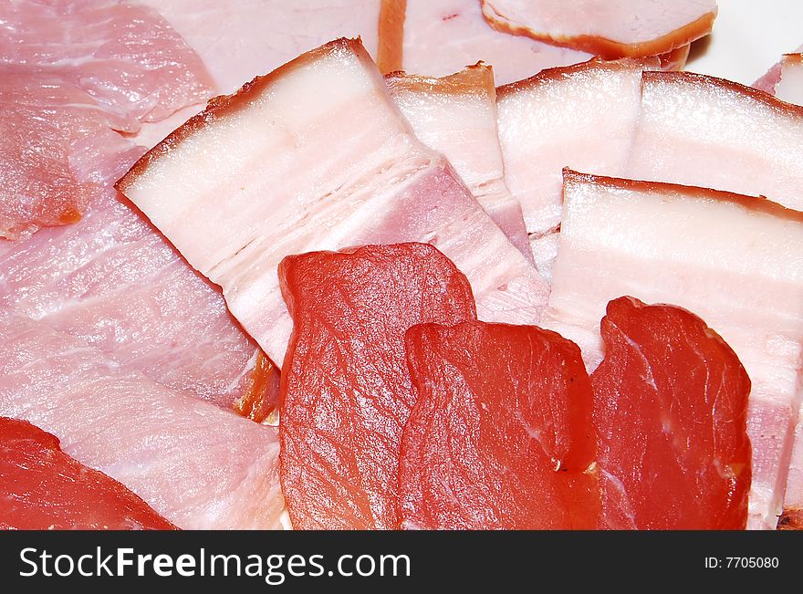 The smoked meat and the fat are cut by slices. The smoked meat and the fat are cut by slices