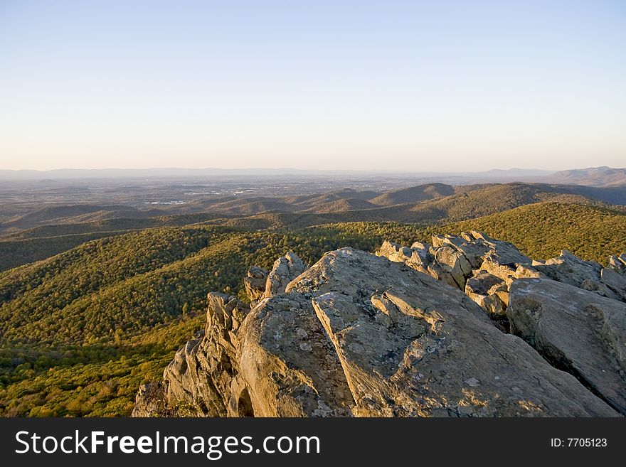 Rock structure over looking autumn mountain range as the sun sets. Rock structure over looking autumn mountain range as the sun sets.