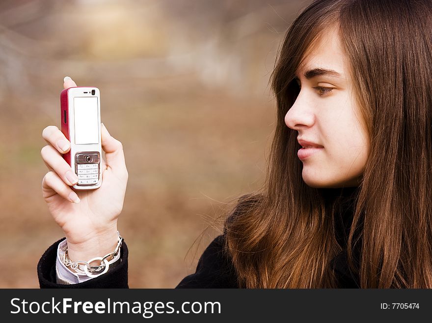 Young Beauty Looking At Her Cell Phone