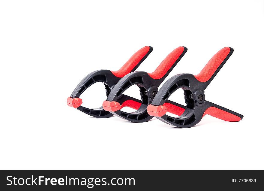 Red and black spring clamps against an isolated white background. Red and black spring clamps against an isolated white background.