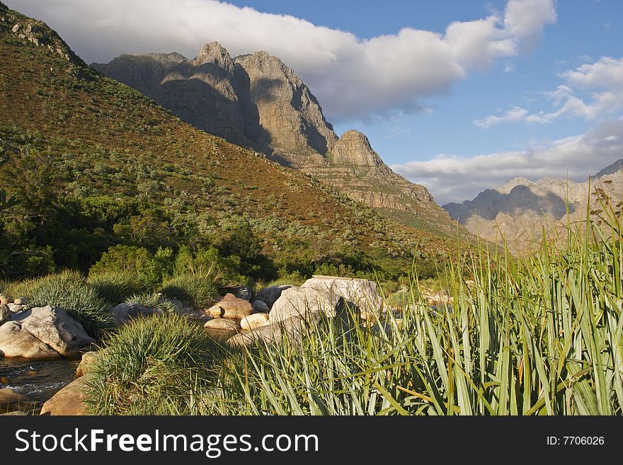 Cape mountains in South Africa framed bya stream and reeds. Cape mountains in South Africa framed bya stream and reeds