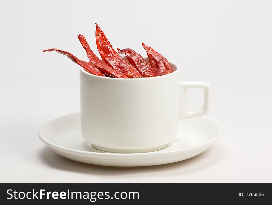 Macro shot of red hot chili peppers with white cup plate. Macro shot of red hot chili peppers with white cup plate