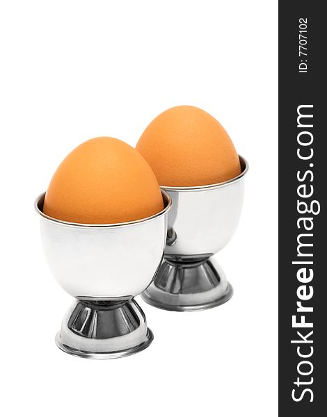 Eggs in metal eggcup on a white background