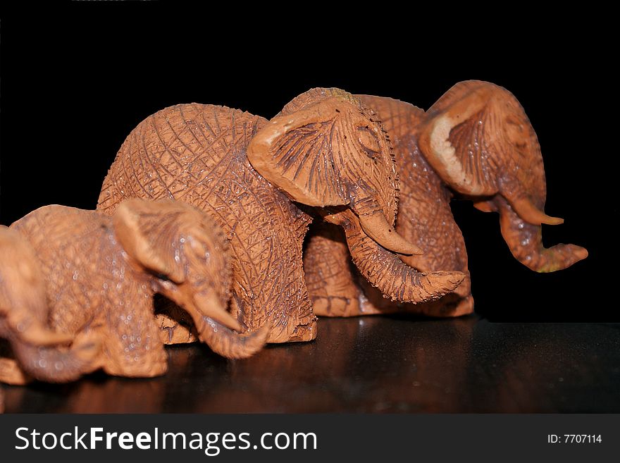 3 Brown clay elephants on a black background