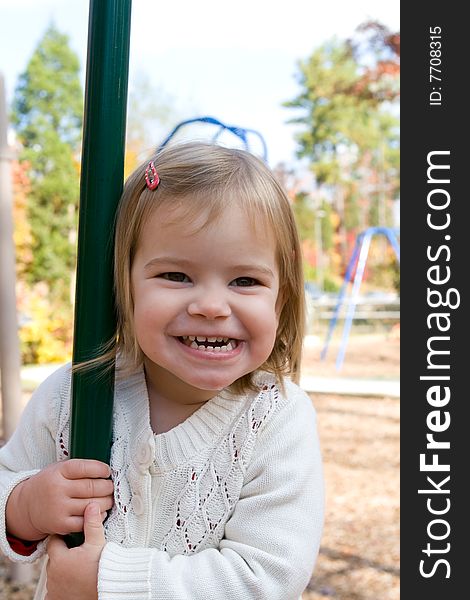 A little girl on the playground on an autumn day