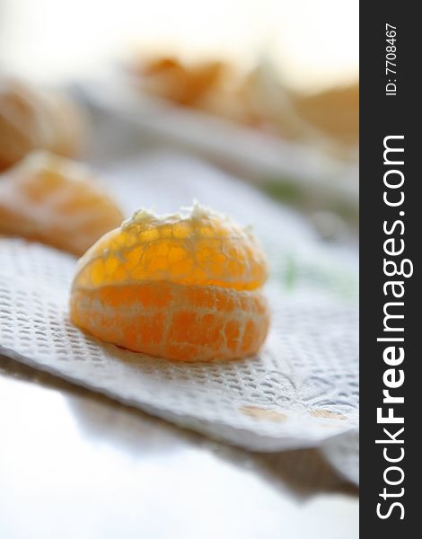 Close up shot of a peeled clementine orange on a napkin ready to eat.