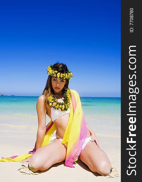 A beautiful young woman in a white bikini at a tropical beach in Hawaii