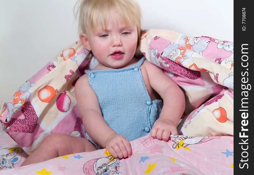 Child pulls blanket on itself