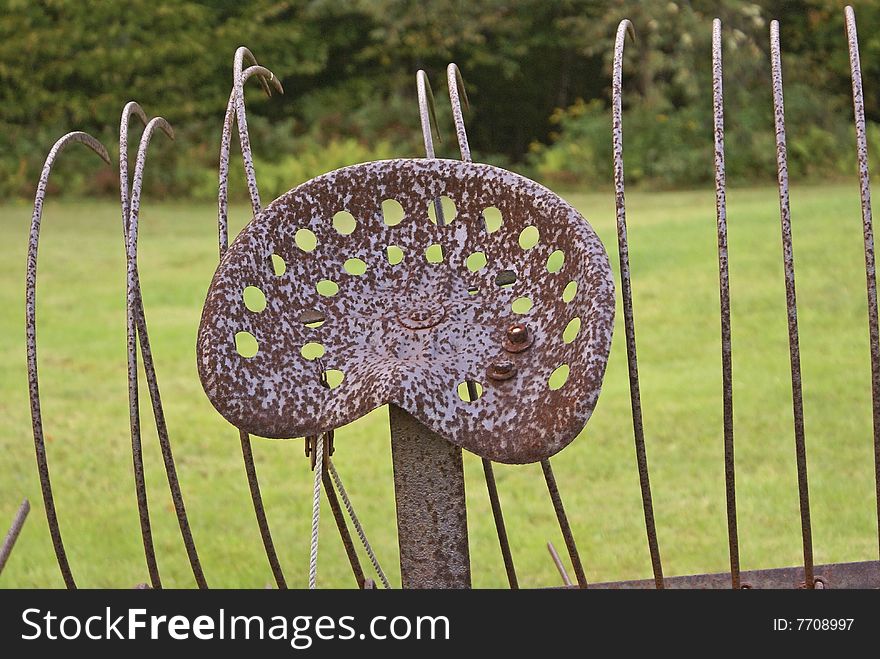 Close up of the seat and tines of an antique hay rake.