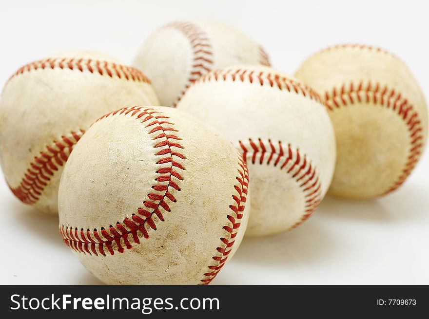 A macro of several baseballs on white