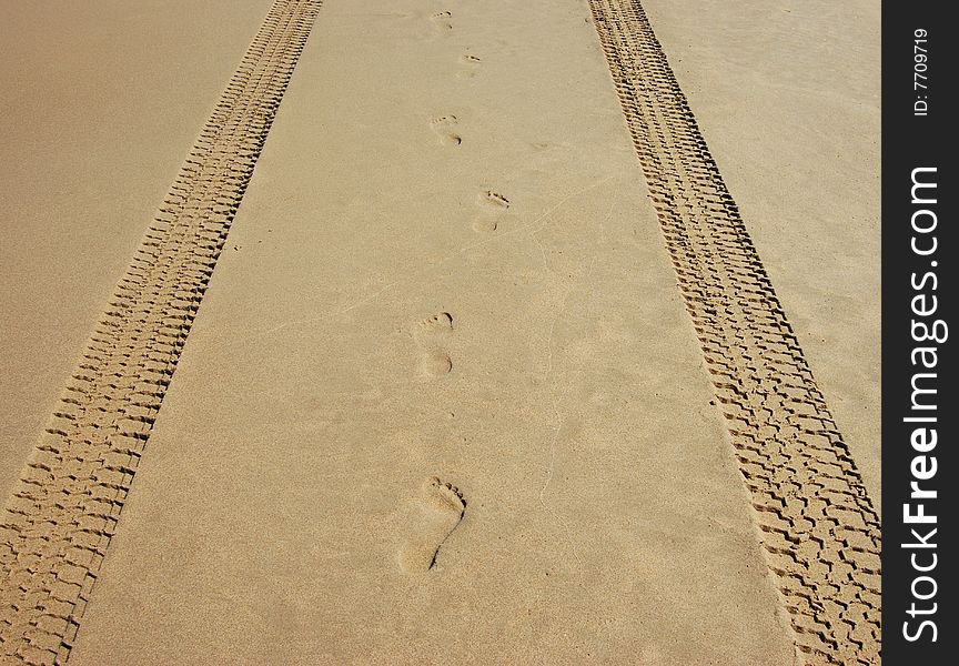 Tyre (Tire) tracks and footprints on a beach early in the morning. Tyre (Tire) tracks and footprints on a beach early in the morning