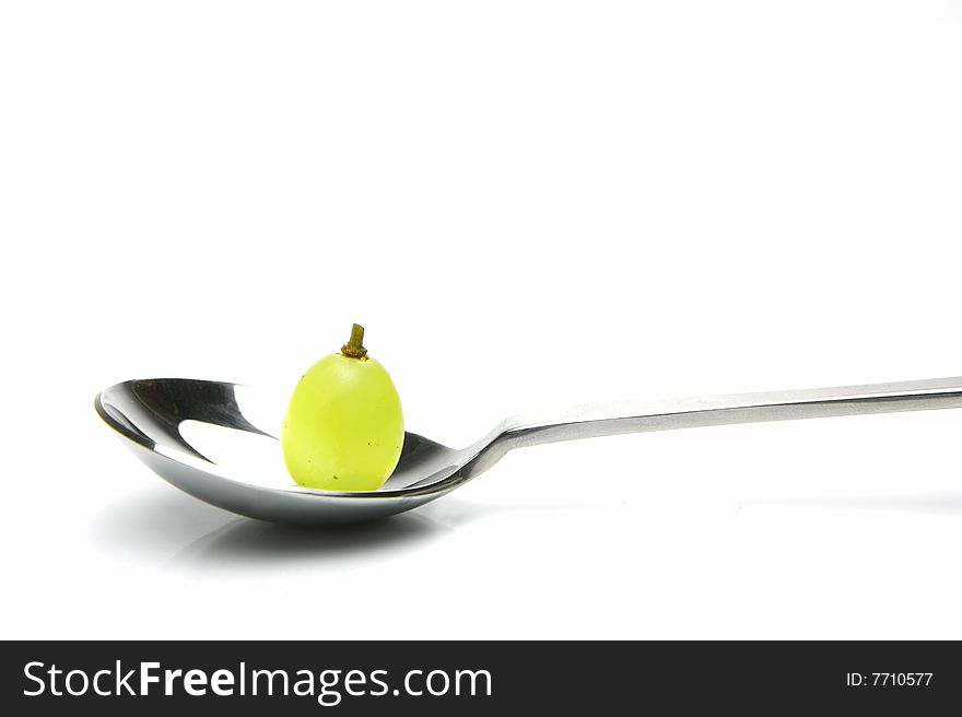 Grapes on a spoon isolated against a white background. Grapes on a spoon isolated against a white background