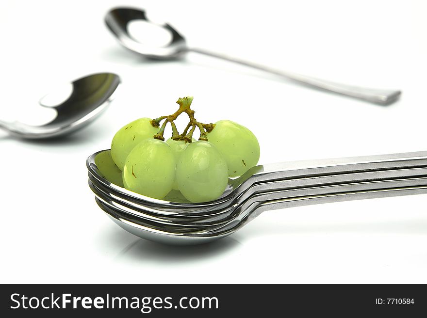 Grapes on a spoon isolated against a white background. Grapes on a spoon isolated against a white background