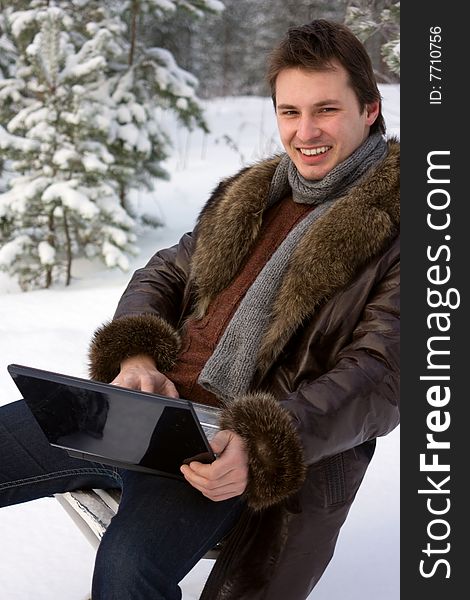 Young smiling man with laptop outdoors. Young smiling man with laptop outdoors