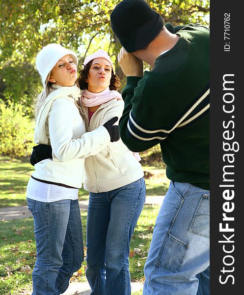 Male caucasian taking picture of two young girls in park. Male caucasian taking picture of two young girls in park