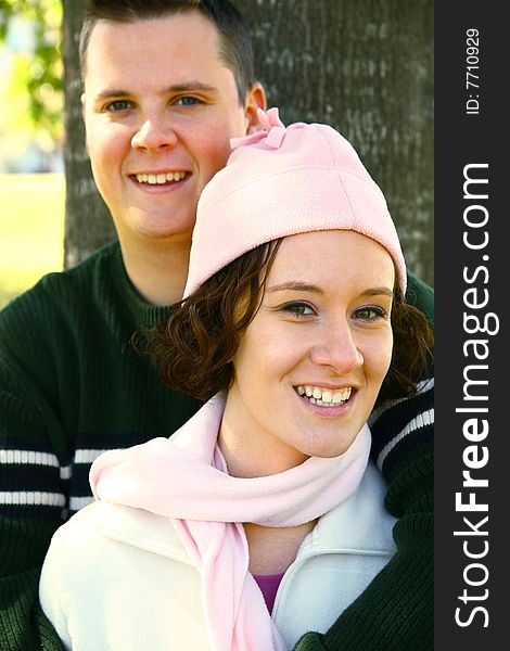 Romantic young couple embracing in park. focus on the woman. Romantic young couple embracing in park. focus on the woman