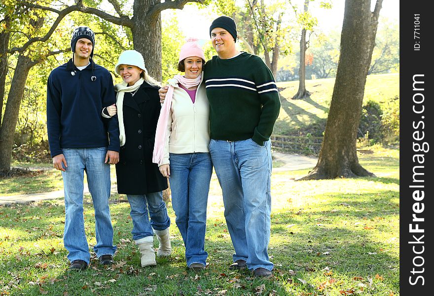 Four happy young male and female caucasian walking outdoor in park. concept for family and happiness. Four happy young male and female caucasian walking outdoor in park. concept for family and happiness