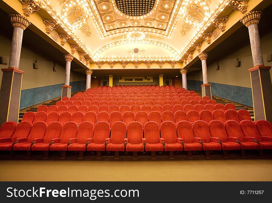 Empty cinema auditorium with red chairs