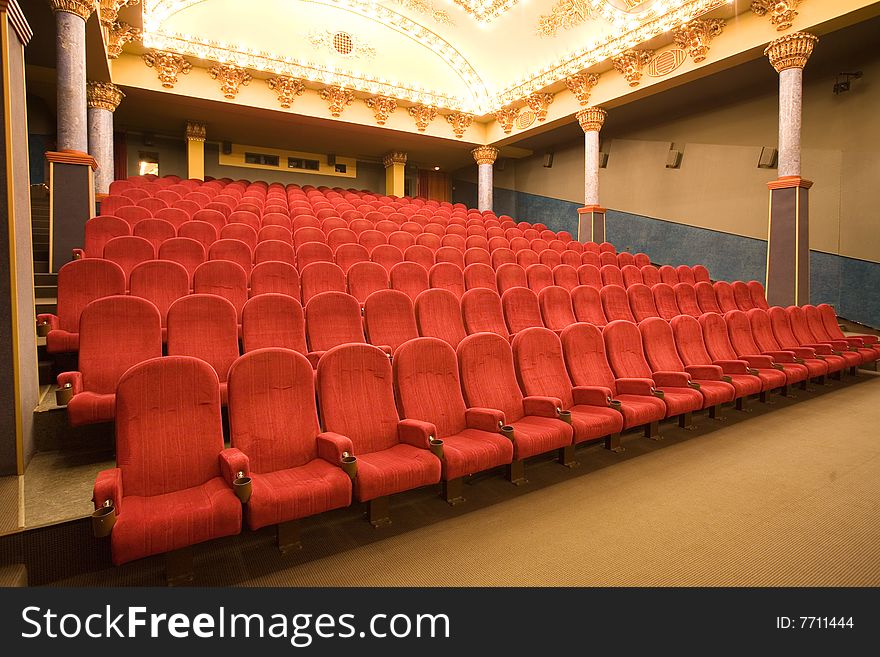 Empty cinema auditorium with red chairs