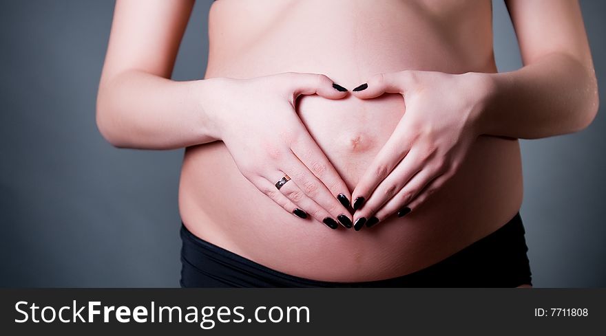 Close-up of pregnant woman holding her belly