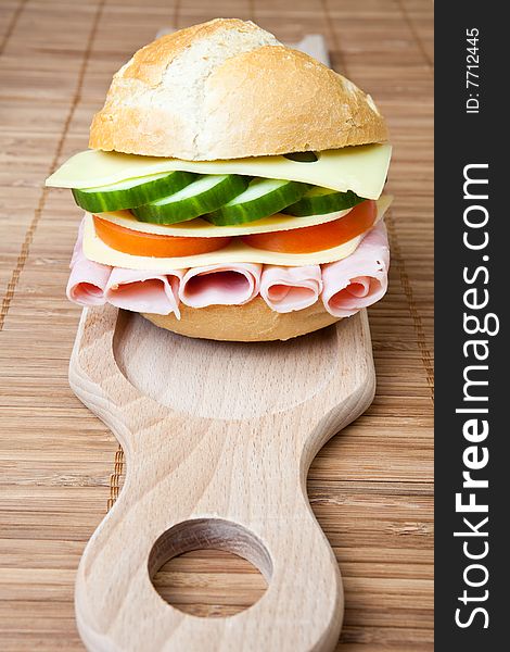 Delicious ham, cheese and salad sandwich on a wooden board