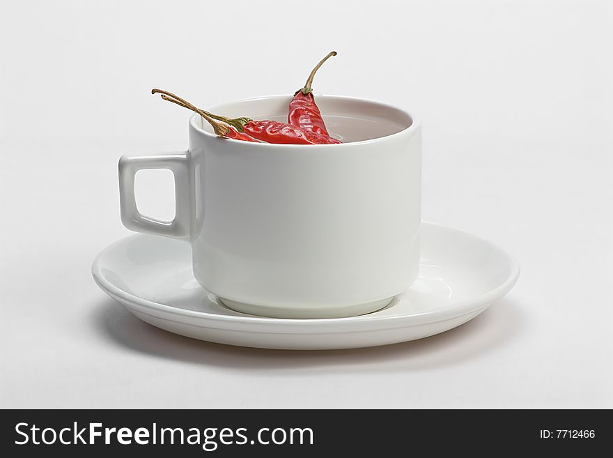 Macro shot of red hot chili peppers with white cup plate. Macro shot of red hot chili peppers with white cup plate