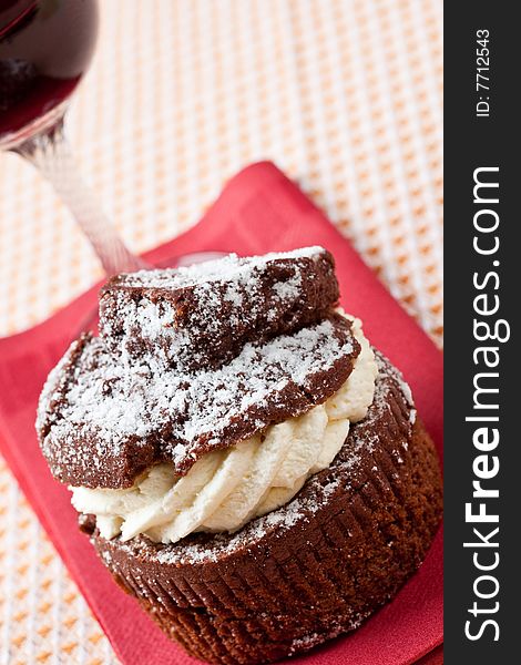 Delicious chocolate and cream muffins with a glass of red wine