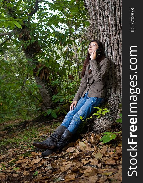 Young woman talking by phone on deep forest. Young woman talking by phone on deep forest