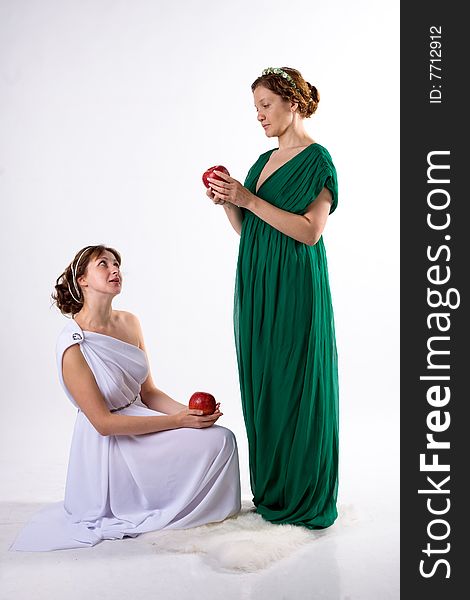 Two ladies in antique dress and two apples on white background. Two ladies in antique dress and two apples on white background