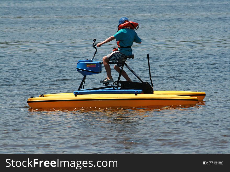 a young white caucasian boy on a paddle boat enjoying his summer vacation