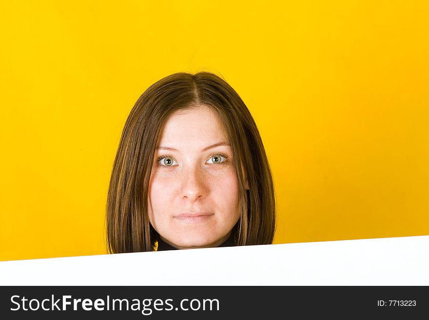 Beautiful woman looking at camera. On yellow background