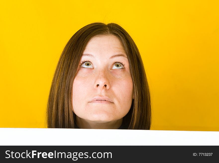 Beautiful woman looking up. On yellow background