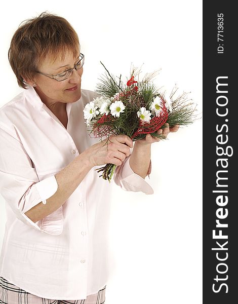 Elderly woman is smelling to flowers