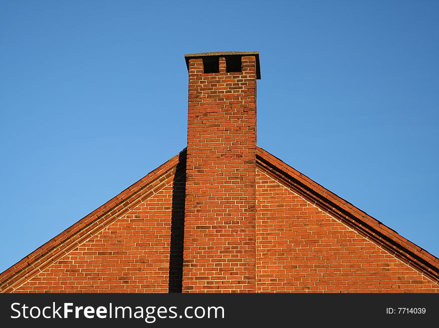 Chimney at a roof top and a blue sky background